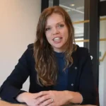 Driven professional woman presenting Keylane career opportunities in a modern office environment; a perfect image for careers in software, tech, and financial services.