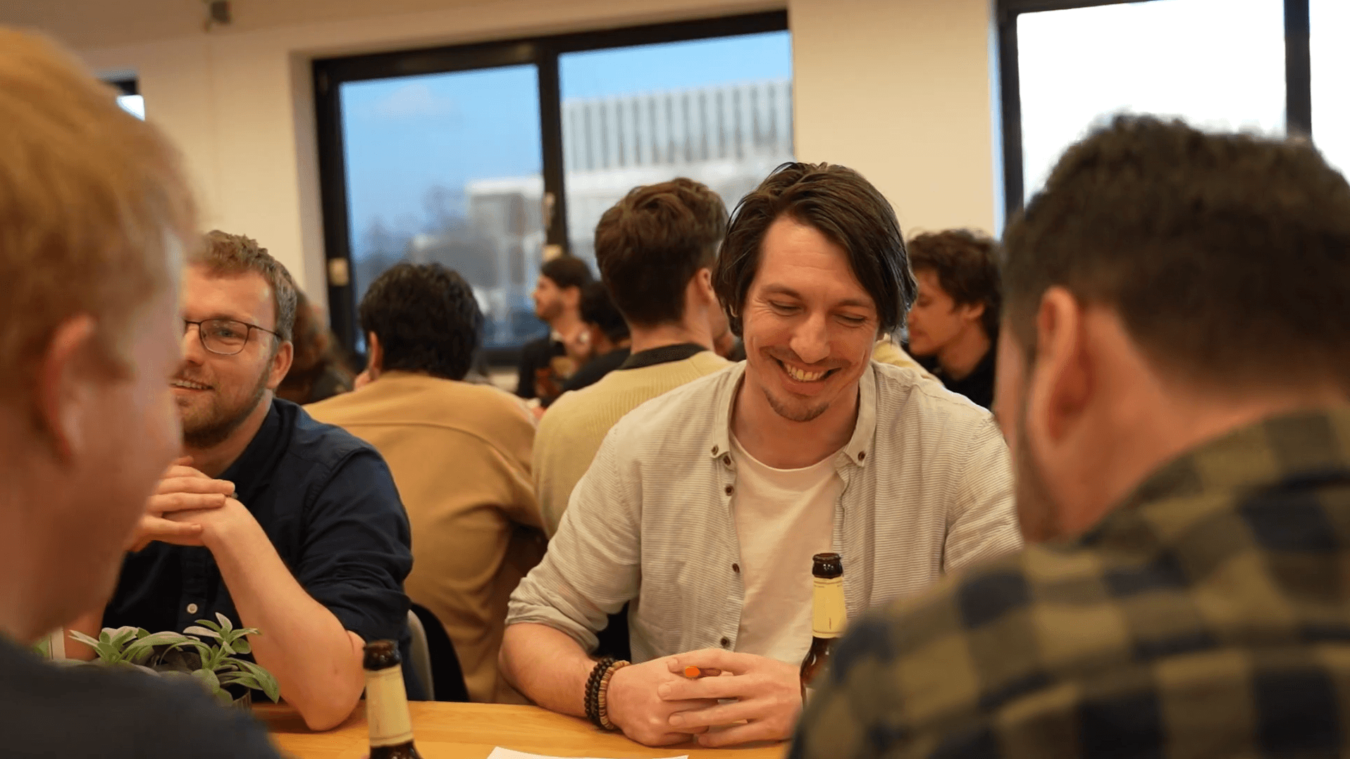 A vibrant office networking event with diverse professionals engaging and sharing ideas, highlighting career growth and company culture at Keylane.