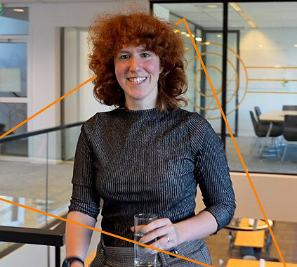 Innovative woman at Keylane Careers event, smiling with glass in hand, professional networking, modern office setting, career growth, technology, insurance industry opportunities, diverse workplace culture.