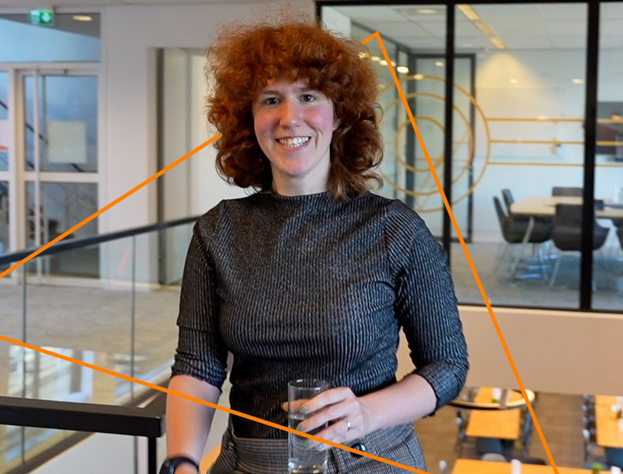 Innovative woman at Keylane Careers event, smiling with glass in hand, professional networking, modern office setting, career growth, technology, insurance industry opportunities, diverse workplace culture.