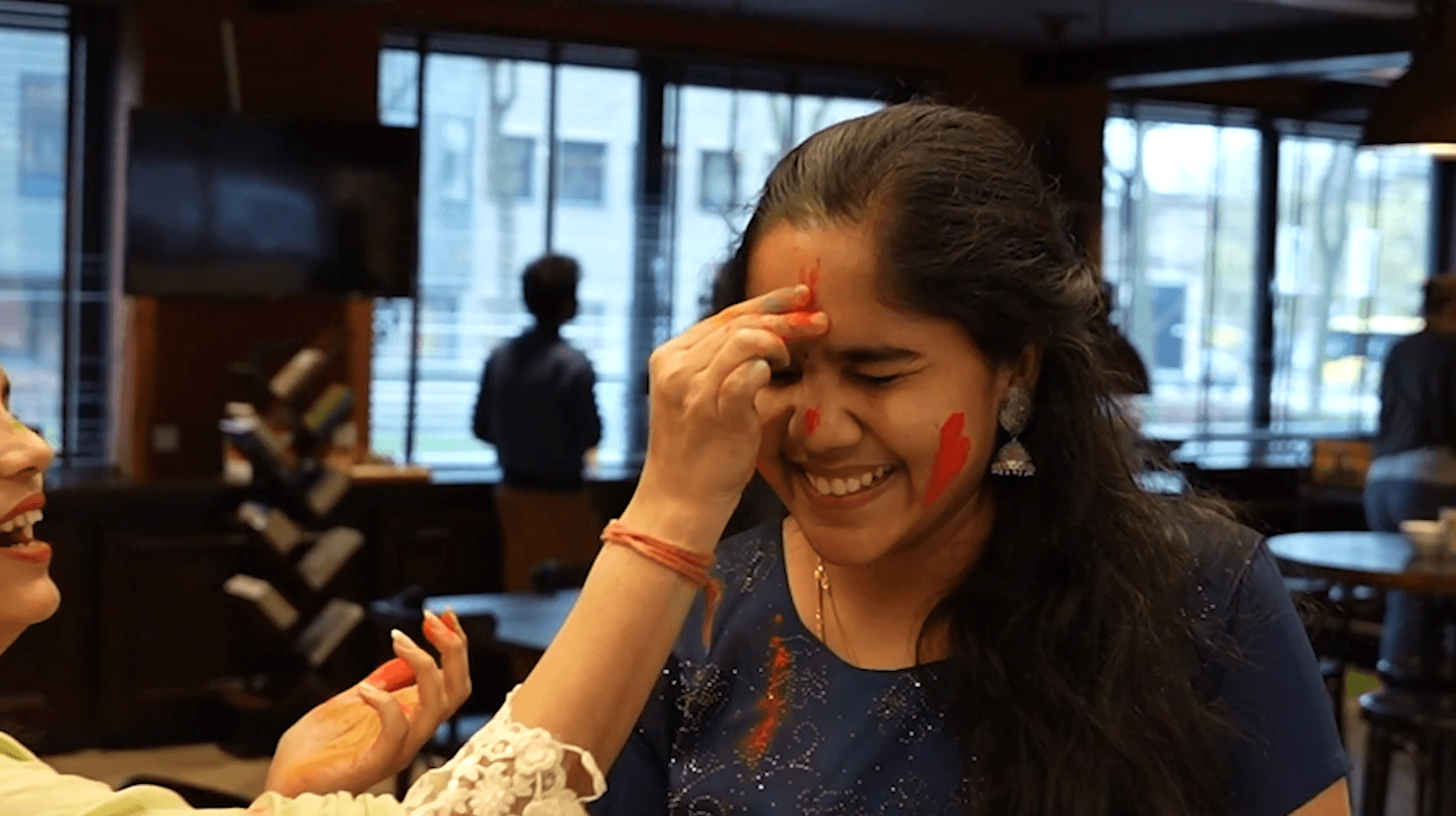 Bright woman at Keylane Careers celebrating a fun, joyful moment with colorful face paint, showcasing a vibrant workplace environment and positive team culture that supports employee happiness and engagement.
