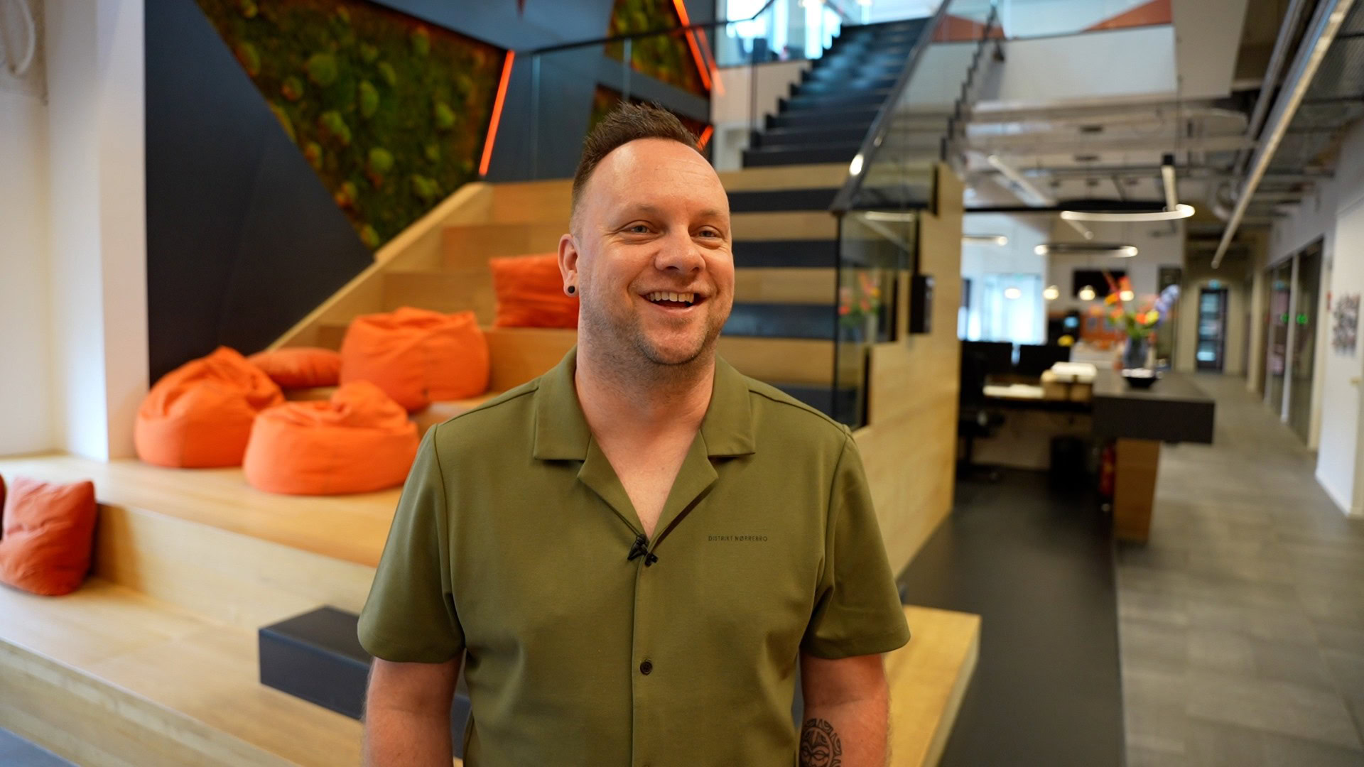 Diverse professional smiling man in modern office environment, modern workspace, modern office interior, professional workplace, collaborative office setting, comfortable work environment, vibrant office design, innovative workspaces, positive work culture.