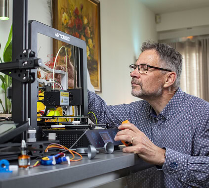 3D printing engineer working on a 3D printer, focused on creating innovative solutions, representing careers at Keylane in technology, software development, and digital innovation.