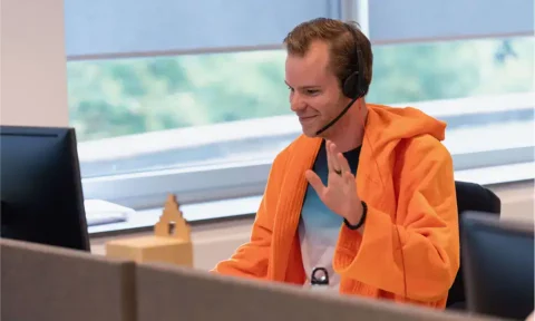 Proactive customer service representative wearing a headset at a modern office, providing support and solutions for client inquiries.