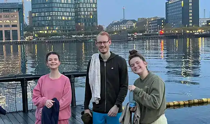 1. Diverse professionals smiling by a waterfront in an urban cityscape, representing Keylane Careers and opportunities in fintech, software development, and insurance technology.