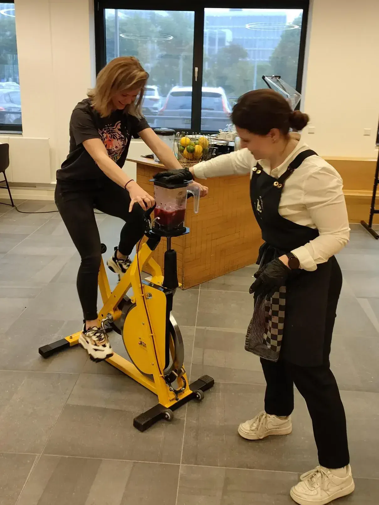 Athletic woman riding a stationary bike in office setting during a team-building event for Keylane Careers.