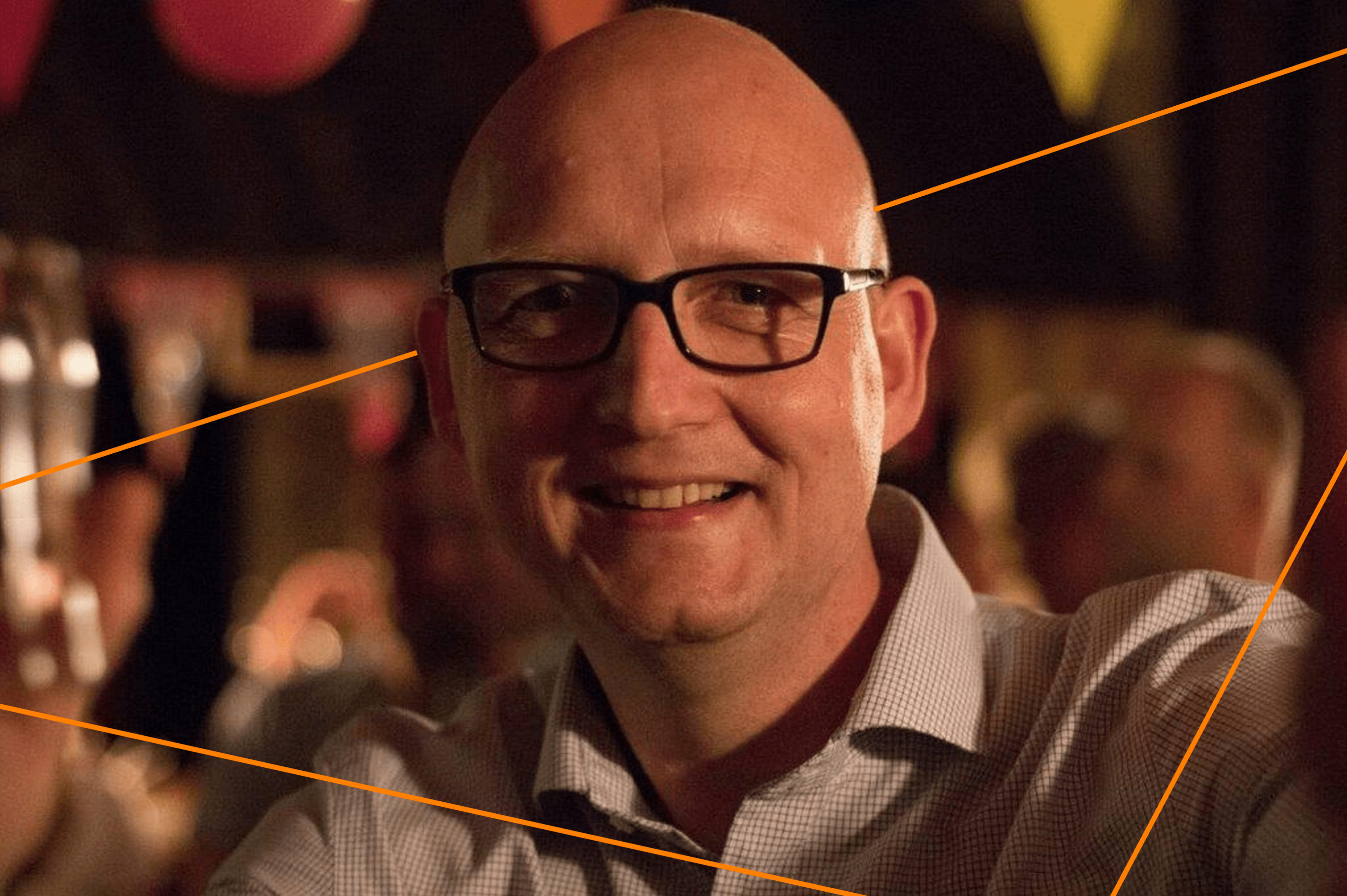 Friendly, professional man smiling at networking event, representing career growth opportunities at Keylane with a focus on innovative insurance tech careers.