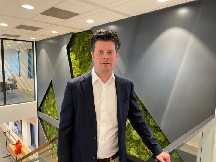 Innovative professional standing in modern office environment, showcasing Keylane's dynamicwork culture and career opportunities in technology and financial services.